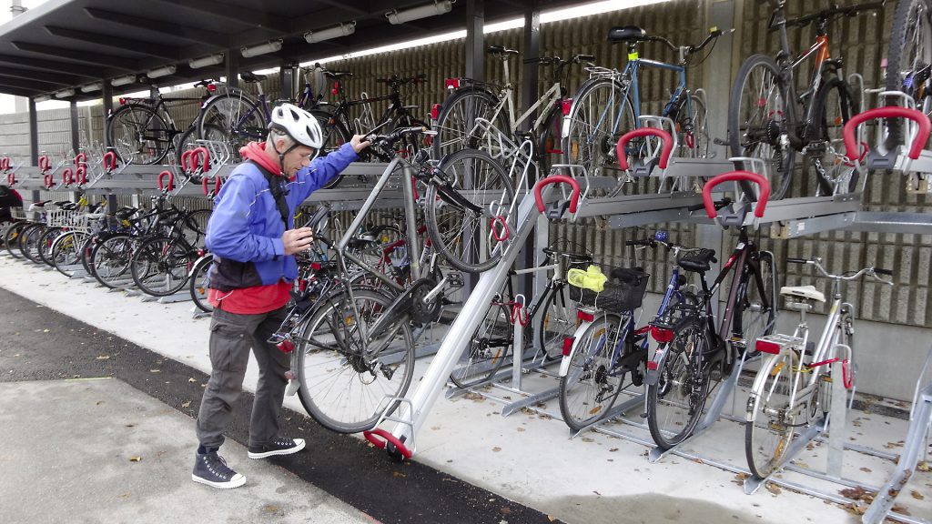 Ein Mann stellt sein Fahrrad auf einen der neuen Fahrradabstellplätze